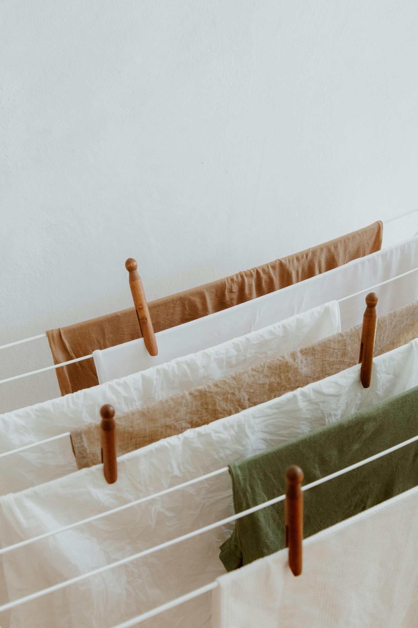 A serene indoor shot of linens drying on a clothesline, showcasing neutral tones and simplicity.