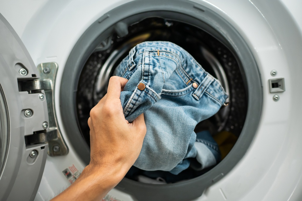A mother and daughter doing laundry together in a cozy indoor setting.