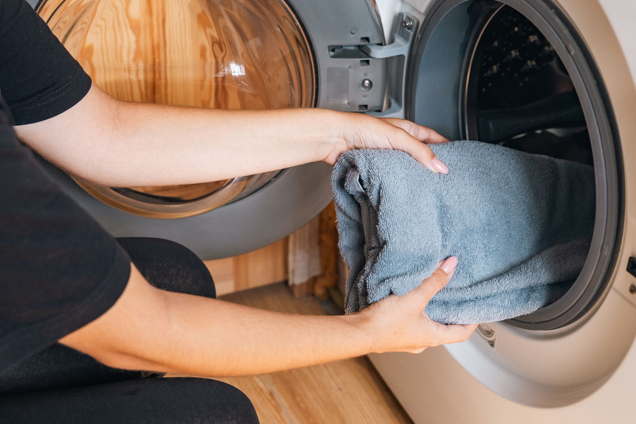 A mother and daughter doing laundry together in a cozy indoor setting.