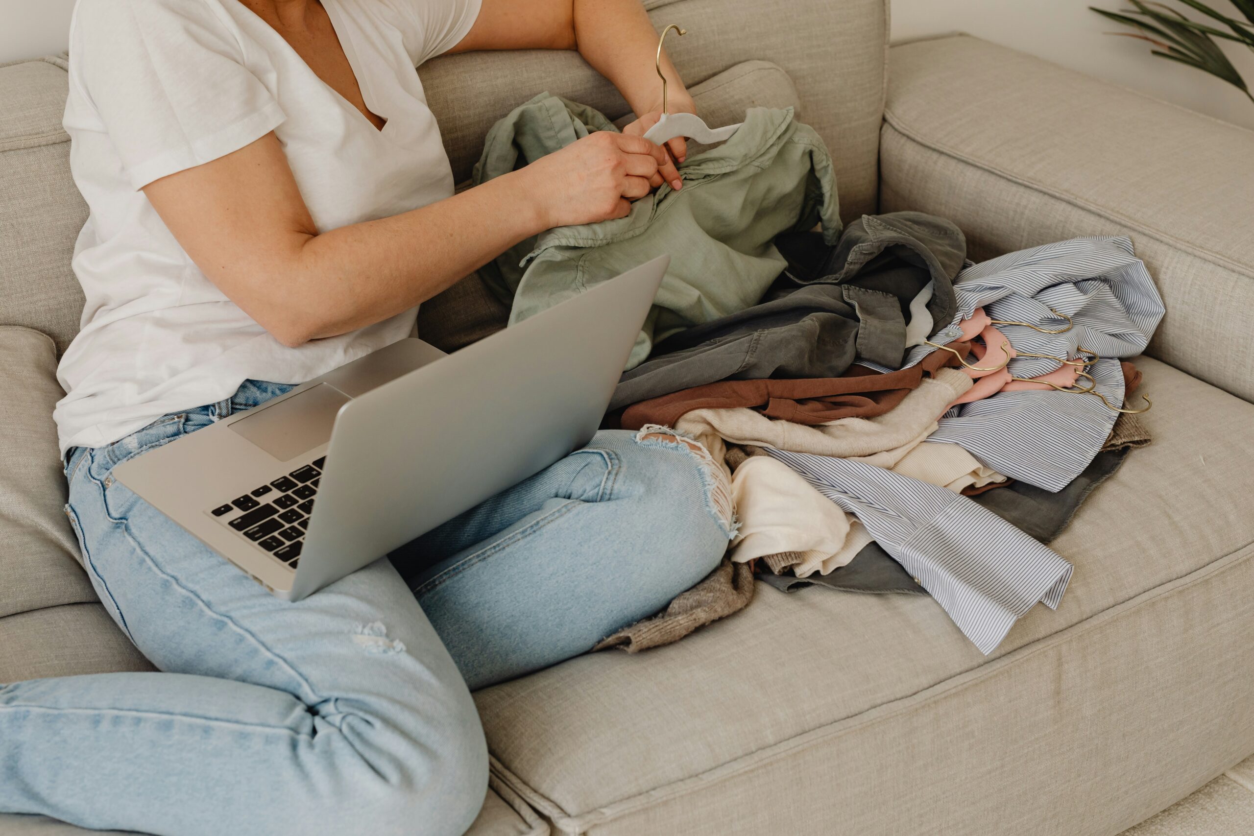 Young barefoot African American female with cup of hot drink standing on floor with dog at home