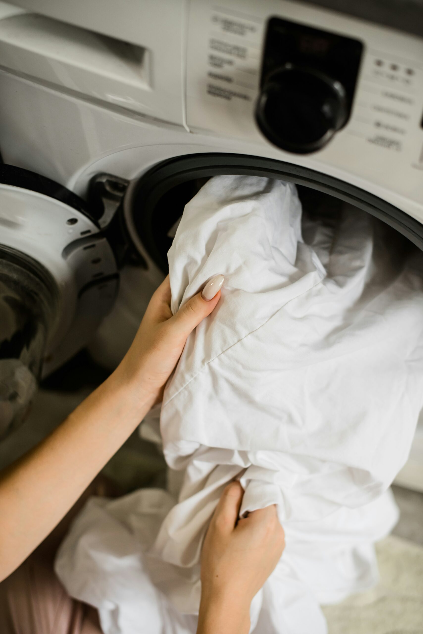 A mother and daughter doing laundry together in a cozy indoor setting.
